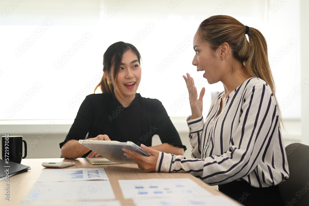 Young woman office worker telling gossips, enjoy friendly conversation with her colleague Young woman office worker telling gossips, enjoy friendly conversation with her colleague