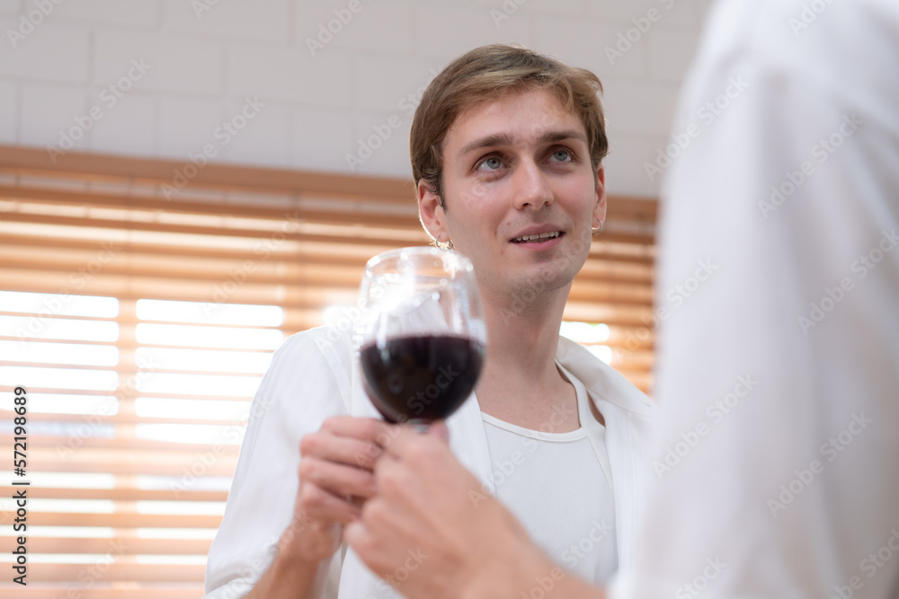 LGBT Young couple celebrate the day of love between each other with fine wine in the kitchen of the house LGBT Young couple celebrate the day of love between each other with fine wine in the kitchen of the house