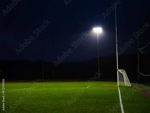 Training ground with grass illuminated by modern powerful LED lights. Efficient modern technology. Nobody. Sport field with tall goal posts for rugby, camogie, hurling and Gaelic football. Irish sport photo