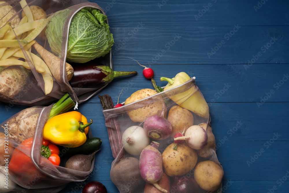 Different fresh ripe vegetables on blue wooden table, flat lay. Space for text