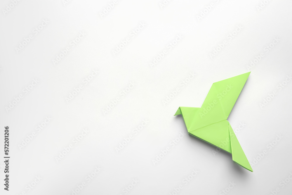 Beautiful light green origami bird on white background, top view. Space for text Beautiful light green origami bird on white background, top view. Space for text