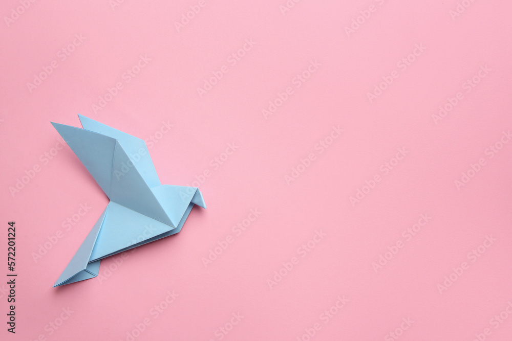 © New Africa - Beautiful light blue origami bird on pink background, top view. Space for text