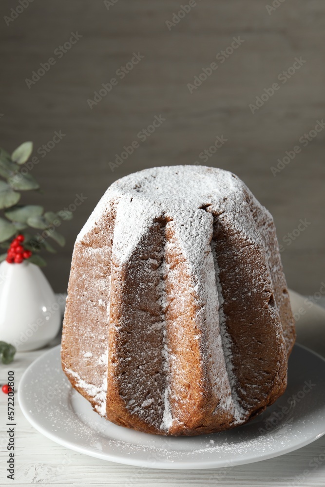Delicious Pandoro cake decorated with powdered sugar on white wooden table. Traditional Italian pastry Delicious Pandoro cake decorated with powdered sugar on white wooden table. Traditional Italian pastry
