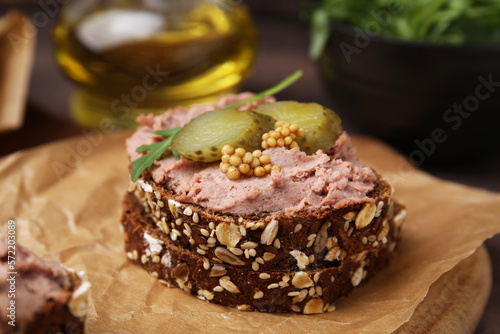 Delicious liverwurst sandwich with pickled cucumber and mustard on table  closeup
