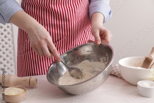 Woman making traditional grissini at white wooden table indoors, closeup