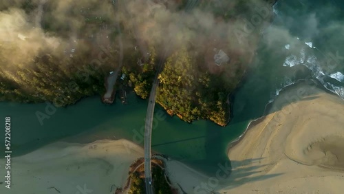 Overhead drone shot of cars driving across a cinematic bridge on California's coast. photo