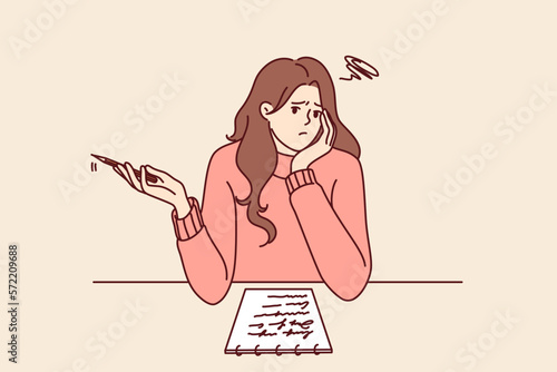 Thoughtful girl sitting at table thinking about what to write in essay given by teacher in university. Thoughtful woman using notepad to make checklist and plan for day to increase productivity 