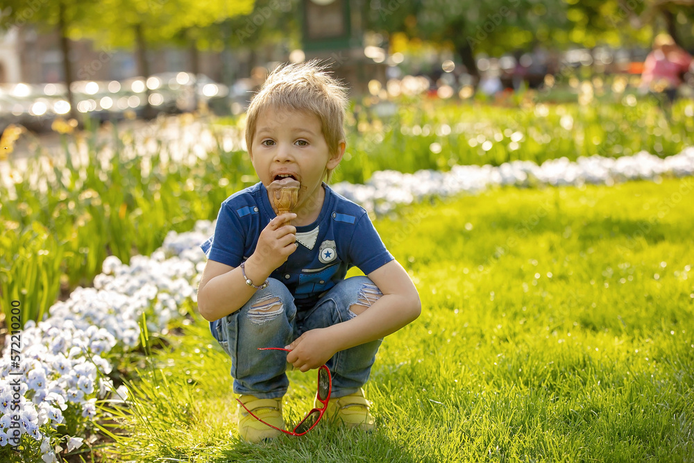 Cute toddler child, eating ice cream outdoors Cute toddler child, eating ice cream outdoors