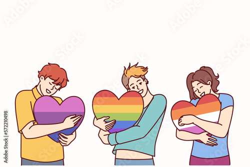 People hugging hearts painted in colors of LGBT and LGBTQ flags making freedom of choice in sex and lifestyle. concept of public tolerance for people from LGBT pride community or transgender people 