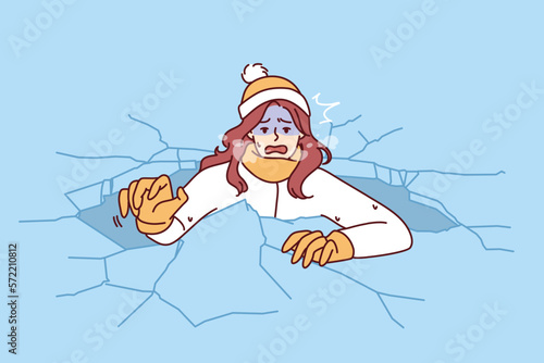 Drowning woman is trying to get out of hole in which fell while walking on frozen lake for concept adverse environmental conditions. Drowning girl got into trouble after natural disaster 