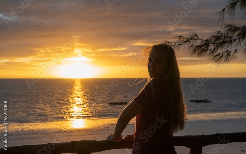 Beautiful young blonde girl enjoying the sunrise on a beach in Zanzibar  Africa 