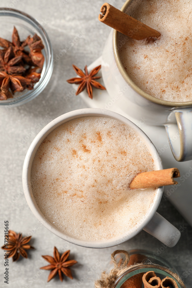 Cups of delicious eggnog with anise and cinnamon on light grey table, flat lay Cups of delicious eggnog with anise and cinnamon on light grey table, flat lay