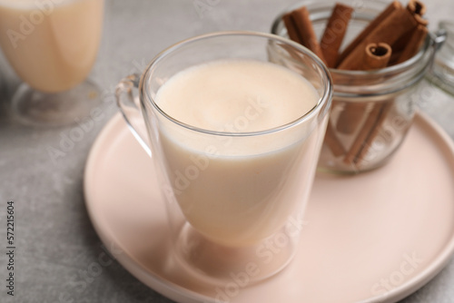 Delicious eggnog with cinnamon on light grey table