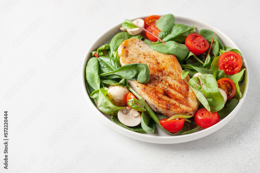 Fresh salad - spinach leaves, tomato, mushrooms, chards leaves and chicken fillet grill in a plate on the table. Healthy diet food. Fresh salad - spinach leaves, tomato, mushrooms, chards leaves and chicken fillet grill in a plate on the table. Healthy diet food.