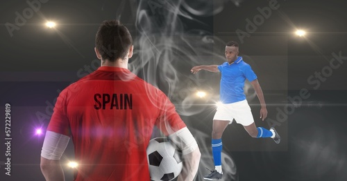 Smoke effect over two male soccer players against spot of lights on grey background © vectorfusionart