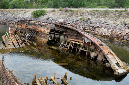 The wreck of an abandoned wrecked ship in the water near the shore