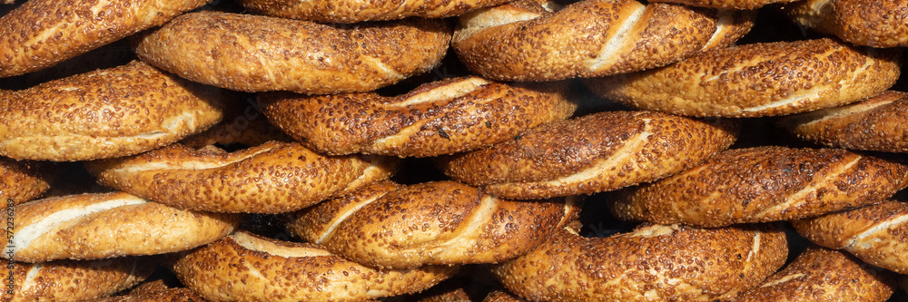 Traditional turkish simit. Stacked turkish bagels with sesame seeds as background. Close-up.