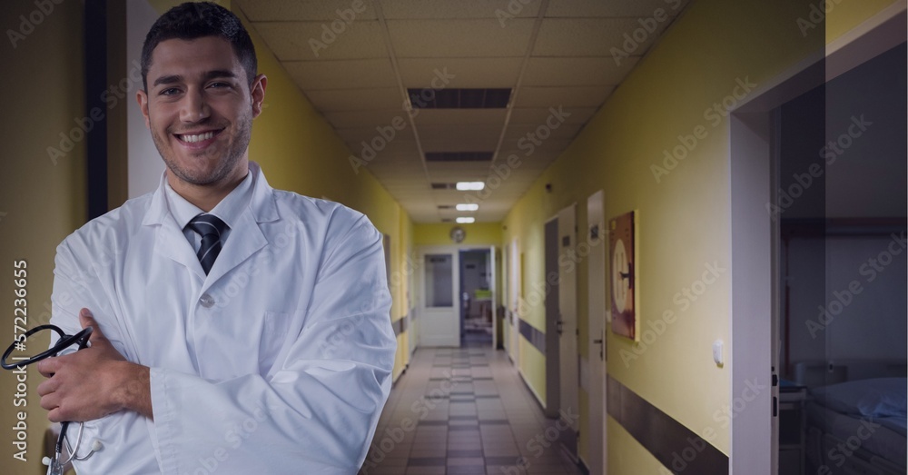 Fototapeta premium Smiling doctor with hospital hallway in the background, healthcare and medical professional concepts