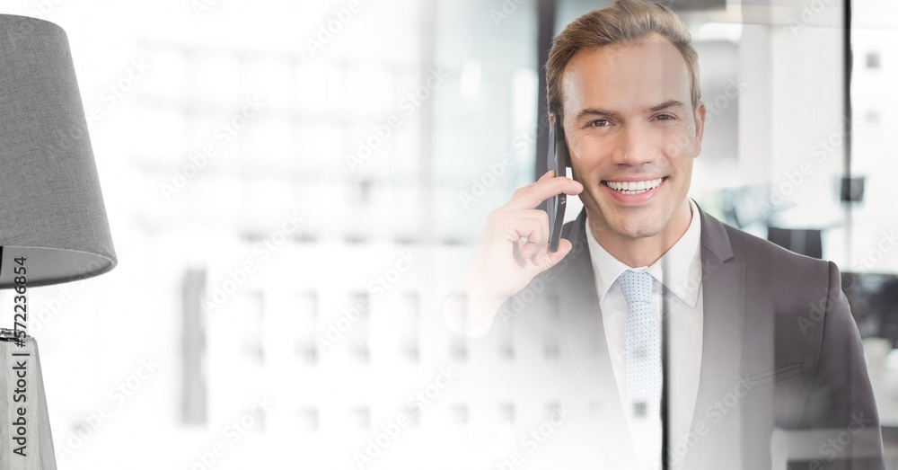 Composition of smiling businessman talking on smartphone in office with copy space Composition of smiling businessman talking on smartphone in office with copy space