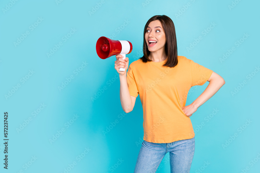 Photo of cheerful cute positive girl dressed yellow t-shirt hold loudspeaker look empty space isolated on turquoise color background Photo of cheerful cute positive girl dressed yellow t-shirt hold loudspeaker look empty space isolated on turquoise color background