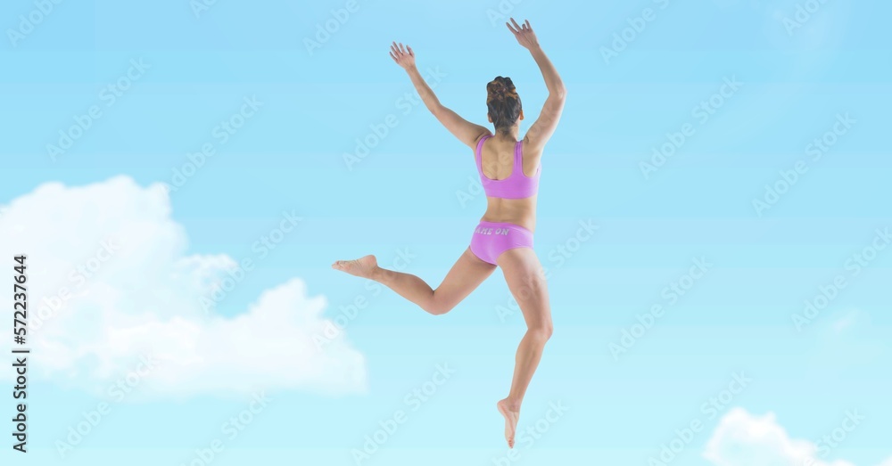 Composition of fit woman in pink underwear jumping over clouds on blue sky Composition of fit woman in pink underwear jumping over clouds on blue sky
