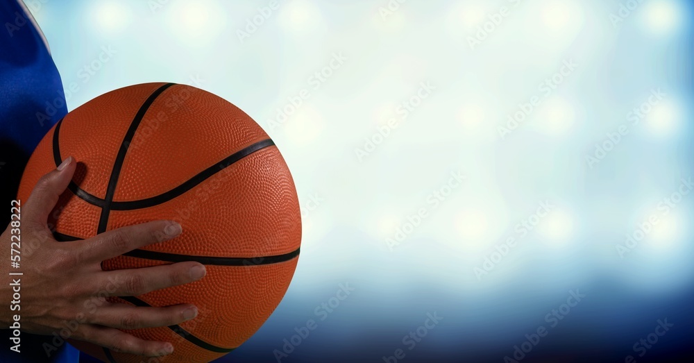 Composition of midsection of female basketball player with ball, spotlights and copy space