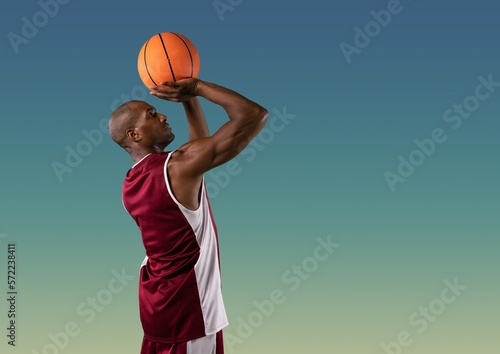 Composition of african american male basketball player with ball and copy space on blue background © vectorfusionart