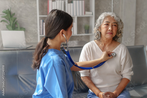 Young asian caretaker with 60s asia elderly woman consulting and encourage, take a history and recommend the right treatment, Use a stethoscope to listen to your heartbeat and check for abnormalities. © NanSan