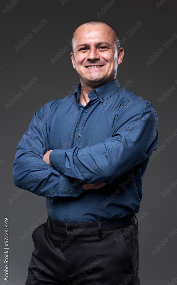 Obraz premium Smiling confident businessman with arms folded