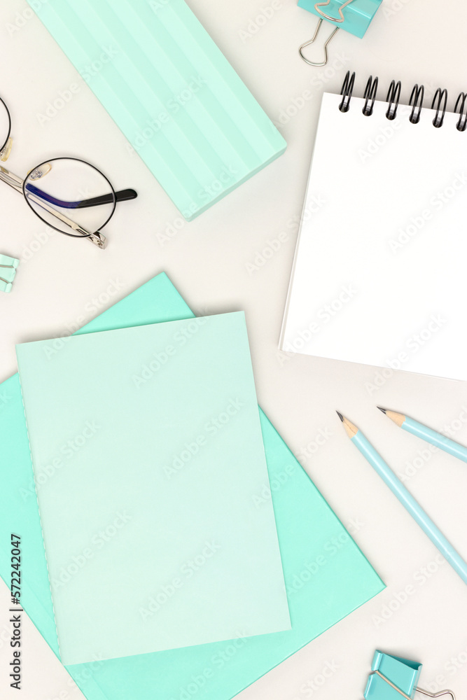 Mint colored school supplies on a gray background. Empty notepad. Mint colored school supplies on a gray background. Empty notepad.
