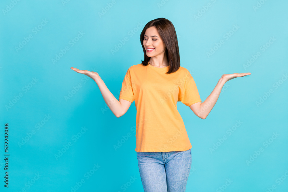 Portrait of nice positive lady look arms palms hold empty space vs scales isolated on blue color background Portrait of nice positive lady look arms palms hold empty space vs scales isolated on blue color background
