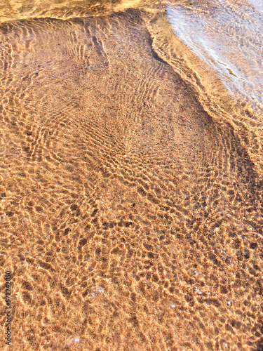 Sandy beach and close up of sea water. Summer natural background.