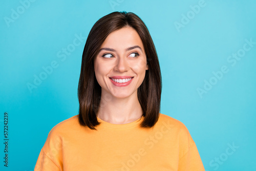 Portrait of optimistic satisfied cute woman with bob hairstyle dressed yellow t-shirt look empty space isolated on blue color background