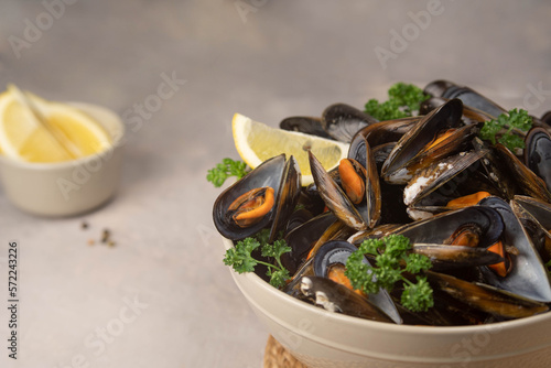 Delicious seafood mussels with with sauce and parsley. Lemon slices. Clams in the shells.