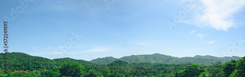 High mountain in day time. Beautiful natural landscape panorama or banner background. Blue sky, Green forest. © sutlafk