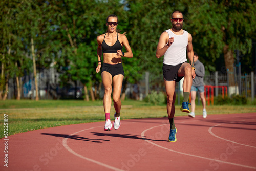 Woman and man jogging in the stadium