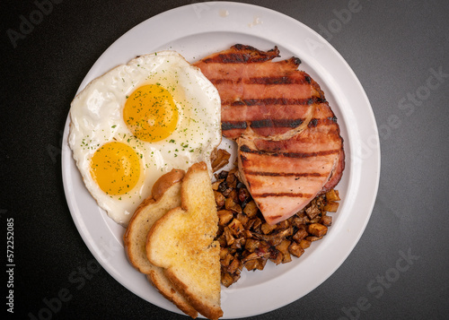 Two eggs, ham, potatoes and toast