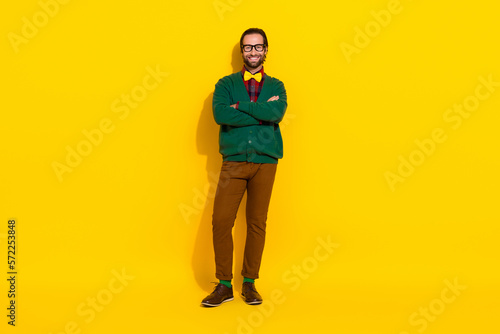 Full size portrait of cheerful satisfied person crossed hands toothy smile isolated on yellow color background