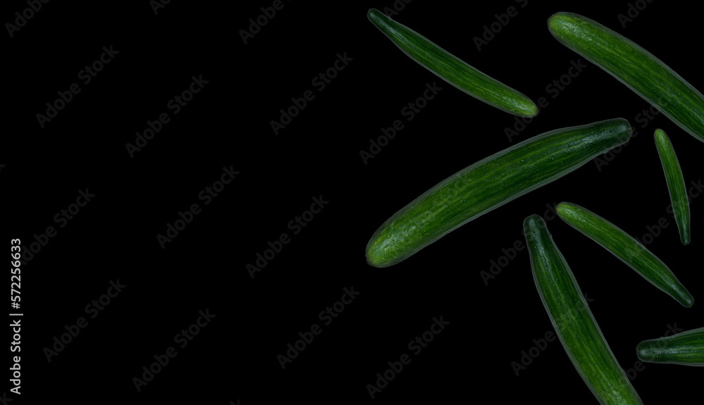 Obraz premium Cucumbers falling, isolated on black background.