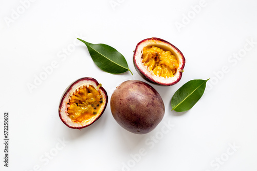 Closeup of whole and half of fresh passion fruit with leaf