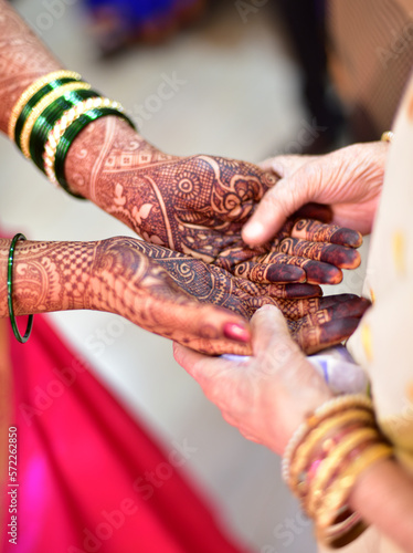 Close up view of hand of a bride and grandparents holding hands together performing rituals in marriage
