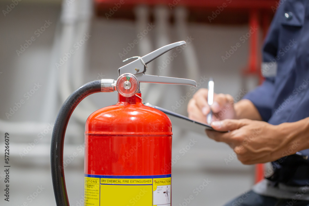 Engineer are checking and inspection a fire extinguishers tank in the fire control room for safety training and fire prevention. Engineer are checking and inspection a fire extinguishers tank in the fire control room for safety training and fire prevention.