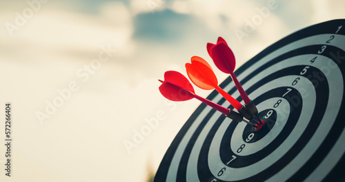 Close up shot of the dart arrow hit on bulleyes of dartboard to represent that the business reached the target  with dark tone picture style. Target and goal as concept. photo