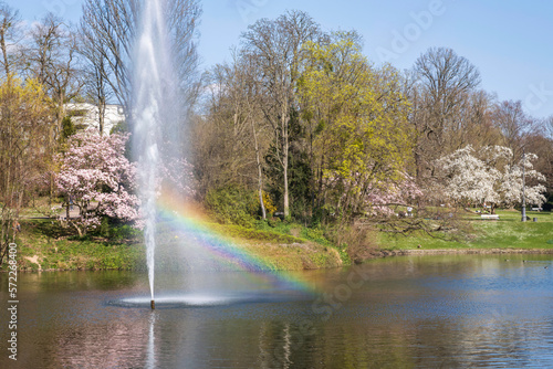 Water fountain with rainbow in the spa park of Wiesbaden/Germany in spring