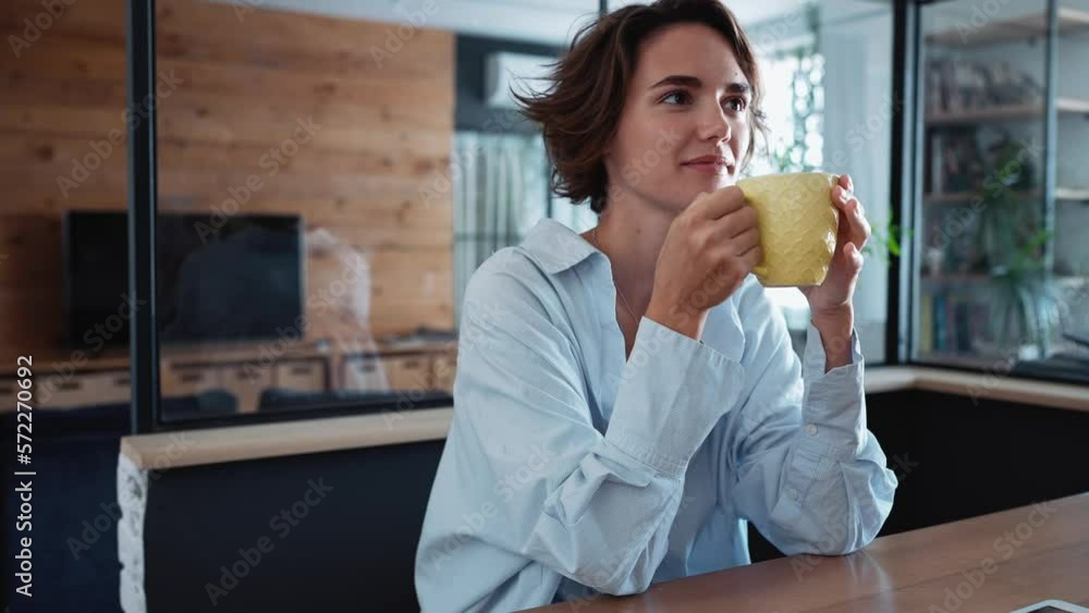 Handsome brunette woman drinking tea and talking about work with her co-worker in the office Handsome brunette woman drinking tea and talking about work with her co-worker in the office