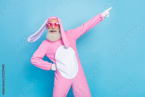 Foto Photo of funky positive man dressed pink rabbit costume sunglass directing empty