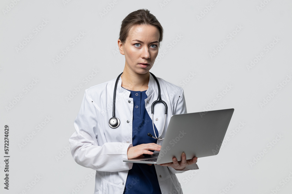 Portrait of a successful doctor with an open laptop who is typing a treatment recommendation Portrait of a successful doctor with an open laptop who is typing a treatment recommendation