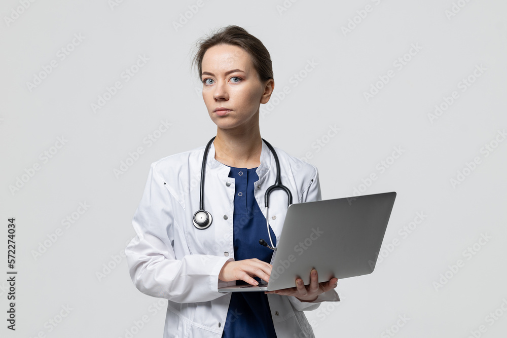 Health care, online doctor's consultation. A young woman in a white coat with a laptop Health care, online doctor's consultation. A young woman in a white coat with a laptop