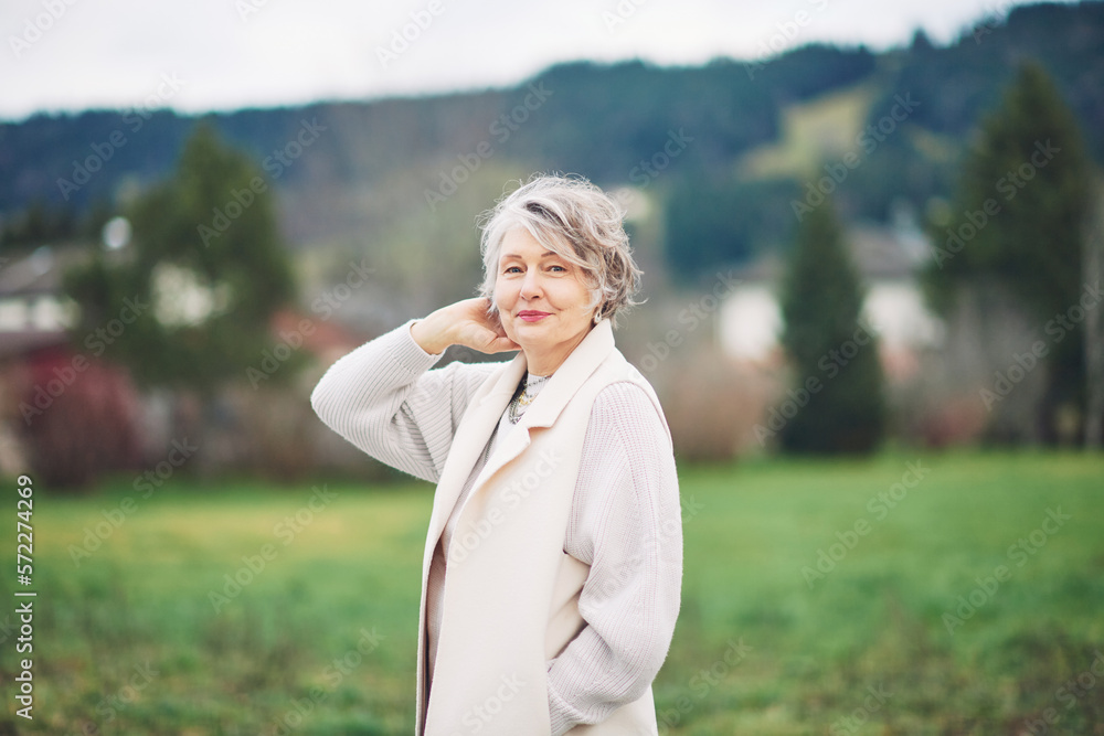 Outdoor portrait of beautiful middle age woman, wearing white coat Outdoor portrait of beautiful middle age woman, wearing white coat