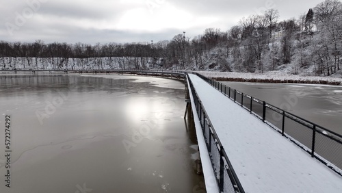 Hiking and walking trail outdoors boardwalk over Genesee River at Turning Point Park, Rochester, NY, during winter with snow  © Steve